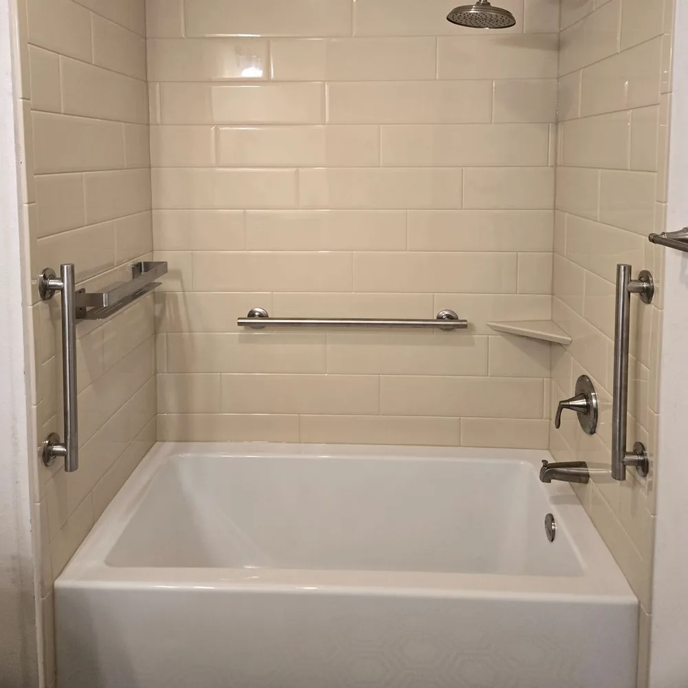Jacuzzi® bathtub with a cream subway-look wall surround and grab bars