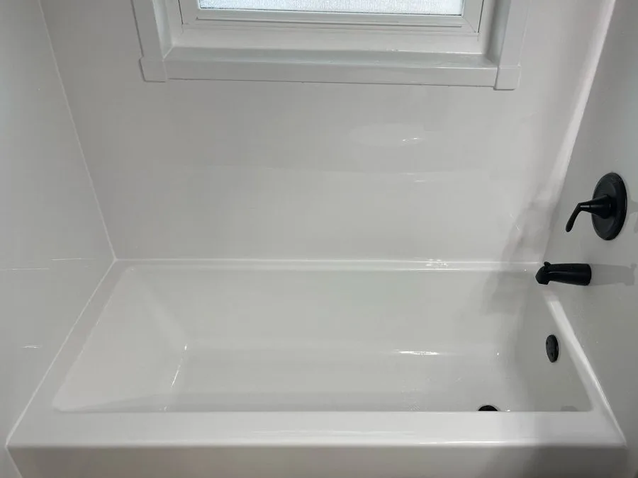Jacuzzi® bathtub with a white wall surround and matte black fixtures